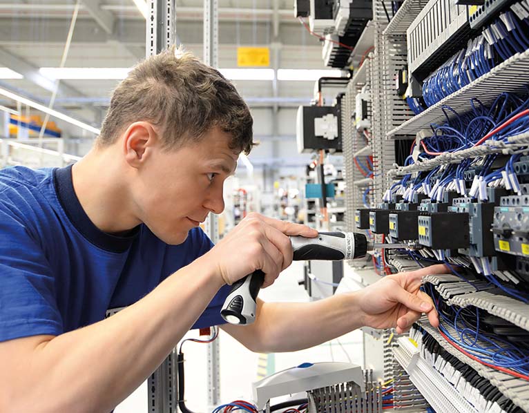 Worker in the control cabinet assembly is supported by digital work instructions