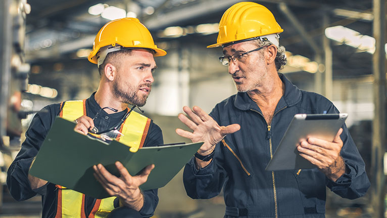 Knowledge retention: an experienced worker passes on his knowledge to a young colleague